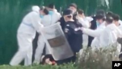 据目击者和社交媒体上的视频称,郑州全球最大的苹果手机工厂的员工在反病毒控制和工资抗纠纷的议活动中遭到殴打和拘留。 (美联社照片)