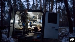 一名随军医护人员在乌克兰卢甘斯克地区撤离一位在与俄军作战中受重伤的乌克兰士兵。(2023年1月13日)