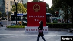 一名女子走过上海街头宣传中国宪法的宣传牌。(2021年11月12日)