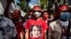 Seorang pengunjuk rasa Burma mengenakan T-shirt bergambar pemimpin sipil Myanmar Aung San Suu Kyi yang ditahan dalam aksi unjuk rasa di luar Kedutaan Besar Myanmar di Bangkok, 19 Desember 2022. (Jack TAYLOR / AFP)