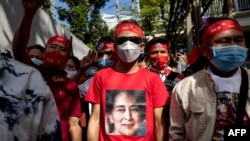 Seorang pengunjuk rasa Burma mengenakan T-shirt bergambar pemimpin sipil Myanmar Aung San Suu Kyi yang ditahan dalam aksi unjuk rasa di luar Kedutaan Besar Myanmar di Bangkok, 19 Desember 2022. (Jack TAYLOR / AFP)