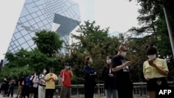 人们在北京的央视大楼旁排队等候进行新冠核酸检测。(2022年6月13日)