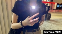 吴小姐开着手机灯到维园一带悼念六四死难者。(美国izhiyin/汤惠芸)