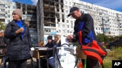 2022年9月24日,在乌克兰东部由俄罗斯支持的分离主义分子控制的顿涅茨克人民共和国马里乌波尔举行的全民公投期间,选民在移动投票站投票。