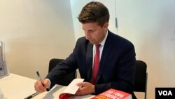 《最后的斗争:中共全球战略大揭秘》作者易思安2022年7月27日在华盛顿一场新书讨论会上为读者签名 (美国之音锺辰芳拍摄)