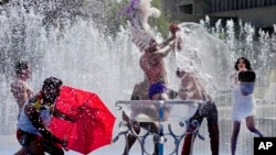 英国高温周二破纪录,人们在伦敦的喷水池里嘻戏。(2022年7月19日)