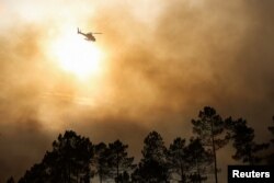 Sebuah helikopter terbang di atas kebakaran hutan di Ourem, distrik Santarem, Portugal 12 Juli 2022. (REUTERS/Rodrigo Antunes)