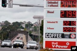 Pengemudi berkendara melewati pameran harga bahan bakar di Sydney, 29 Maret 2022. (Foto: AP)