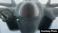 ស្ត្រីម្នាក់កាន់រូបថតប្រធានាធិបតីបារាំង Emmanuel Macron ដែលគេគូជារូបរាជវង្សដោយមានសញ្ញានៅខាងលើសរសេរថា «១៤ ឧសភា ២០១៧ ស្តារឡើងវិញនូវរបបរាជានិយម»។ ស្ត្រីរូបនេះចូលរួមធ្វើបាតុកម្មប្រឆាំងនឹងការរុះរើប្រាក់សោធនិវត្តន៍ នៅទីក្រុងប៉ារីស។