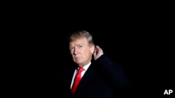 川普在白宫南草坪走下“海军陆战队一号”专用直升机时听记者提问。(2017年12月5日)