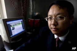 中国律师刘晓原在他的办公室里,旁边的电脑显示他的文章(2007年10月12日)