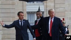 美国总统特朗普在抵达巴黎爱丽舍宫时受到法国总统马克龙的欢迎。(2018年11月10日)