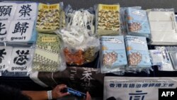 资料照片:2021年7月22日,在香港警方的新闻发布会上,媒体成员拍摄证据,包括试图解释香港民主运动的儿童书籍。此前,五人因出版这些书籍而被控煽动叛乱。
