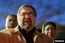 北卡罗来纳大学的学生为遇害的穆斯林举行烛光守夜活动时播放录像,遇难者的父亲哭泣