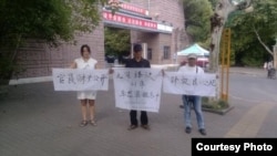 维权人士刘沙沙等中秋节在江西省新余市公安局举牌抗议 (图片来自刘沙沙推特)