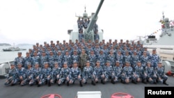 2018年4月12日,在南中国海上,中国国家主席习近平在长沙号驱逐舰上阅兵,同中国人民解放军海军军人合影留念。