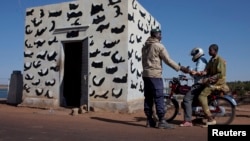 Một binh sĩ Mali kiểm tra căn cước của những người đi qua một cây cầu chiến lược