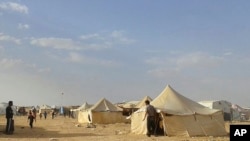 叙利亚人走过约旦同叙利亚东北部边界的拉克班难民营(2016年6月22日,资料图片)