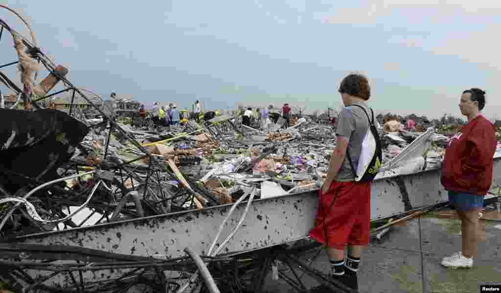 Cư dân đứng xem nhân viên cứu hộ đào bới đống đổ nát để tìm người sống sót sau cơn lốc xoáy ở thị trấn Moore, Oklahoma, ngày 20/5/2013. 