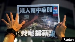 一名苹果日报的支持者手拿一份最后一期的苹果日报。(2021年6月24日)