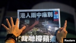 一名苹果日报的支持者手拿最后一期的苹果日报(路透社2021年6月24日)