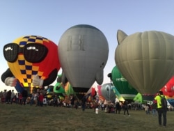 During a sunrise Mass Ascension, hundreds of hot air balloons take off from Balloon Fiesta Park in Albuquerque, N.M., Oct. 12, 2019. (J.Taboh/VOA)