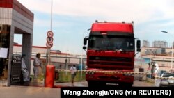 中国发现非洲猪瘟后,河南省郑州肉类加工企业双汇集团大门处可以看到身着防护服的工人。(2018年8月17日)