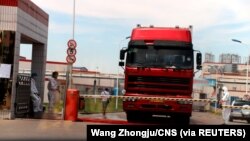 中国发现非洲猪瘟后,河南省郑州肉类加工企业双汇集团大门处可以看到身着防护服的工人。(2018年8月17日)