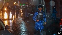 在总统亚明宣布紧急状态后,马尔代夫警察手持警棍冲向首都马累街头的抗议者。(2018年2月6日)
