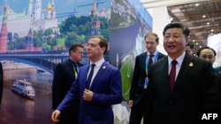 资料照片: 2018年11月5日时任俄罗斯总理梅德韦杰夫和中国国家主席习近平在上海参加首届中国国际进口博览会