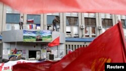 Những người biểu tình thân Nga đứng tại văn phòng dịch vụ an ninh quốc gia SBU bị chiếm ở Luhansk, miền đông Ukraine, 18/4/2014.