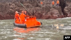 资料照片: 2024年3月14日台湾海警队成员(橙色头盔)与中国海警队参与联合搜救中国倾覆渔船