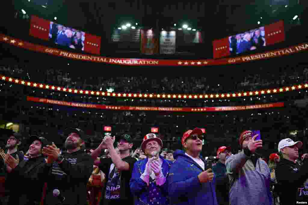 2025 年 1 月 20 日,华盛顿,美国总统唐纳德·特朗普(Donald Trump)的支持者们在就职典礼当天举行的室内集会上鼓掌。