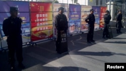 携带防暴装备的警察在新疆法院附近的检查站站岗,从9月17日开始,该法院开始审理伊力哈木的案子。