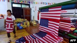 一名中国工人在安徽阜阳的一个制作美国国旗的车间走过。(2018年7月13日)