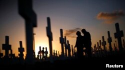 Một cặp vợ chồng đau buồn tại một ngôi mộ trong nghĩa trang Coral Gables, Florida, ngày 16 tháng 2 năm 2008.