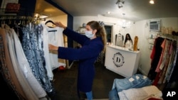 5月9日,科罗拉多州丹佛市准许商店重新开门营业。店员斯塔克整理商品,店主莫利在柜台忙碌。