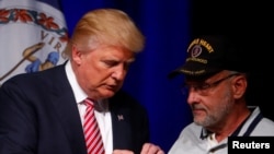 共和党总统候选人川普在维吉尼亚州阿什本的一个竞选活动中和送他紫心勋章的退伍中校路易斯·多夫曼交谈(2016年8月2日)