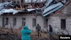 俄罗斯周四导弹袭击乌克兰第聂伯罗市,居民走在一座被炸毁的房屋前。(2024年11月21日)