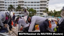 搜救队员6月29日在佛罗里达瑟夫塞德(Surfside)一座部分坍塌的公寓楼现场搜寻。(路透社照片)