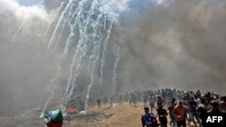 巴勒斯坦人在加沙地带边界附近逃避以色列部队发射的催泪瓦斯,巴勒斯坦人抗议美国大使馆迁往耶路撒冷。