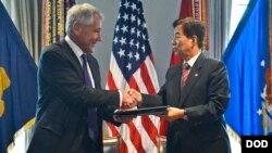 A Chinese People's Liberation Army soldier adjusts a hat of a member of an honor guard as they prepare a welcome ceremony for visiting Nigeria's President Muhammadu Buhari outside the Great Hall of the People in Beijing.