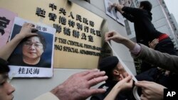 香港民众在北京驻香港机构中联办前高举铜锣湾书店老板桂民海的肖像,要求中国政府释放桂民海。(2016年1月19日)