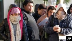 Tư liệu - Người nhập cư chống chọi thời tiết lạnh đứng xếp hàng bên ngoài văn phòng Sở quản lý Xe Cơ giới California để đăng ký bằng lái xe ở Stanton, California, ngày 2 tháng 1, 2015.