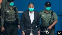 资料照:香港壹传媒创办人黎智英2020年12月12日在出庭前由惩教署人员押送上囚车。(美联社)