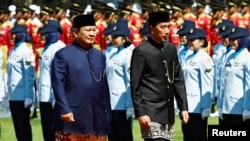 印尼新任总统普拉博沃(左)和前总统维多多(右)在交接中并肩而行,普拉博沃将自身打造成“维多多接班人”,强调政策的“连续性”。(路透社:2024年10月20日)