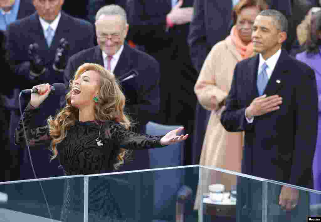 Trên khán đài, ca sĩ Beyonce hát quốc ca, phía sau là Tổng thống Obama và Thượng nghị sĩ Charles Schumer của New York (đeo kính) tại lễ nhậm chức nhiệm kỳ hai của Tổng thống Obama. (Reuters)