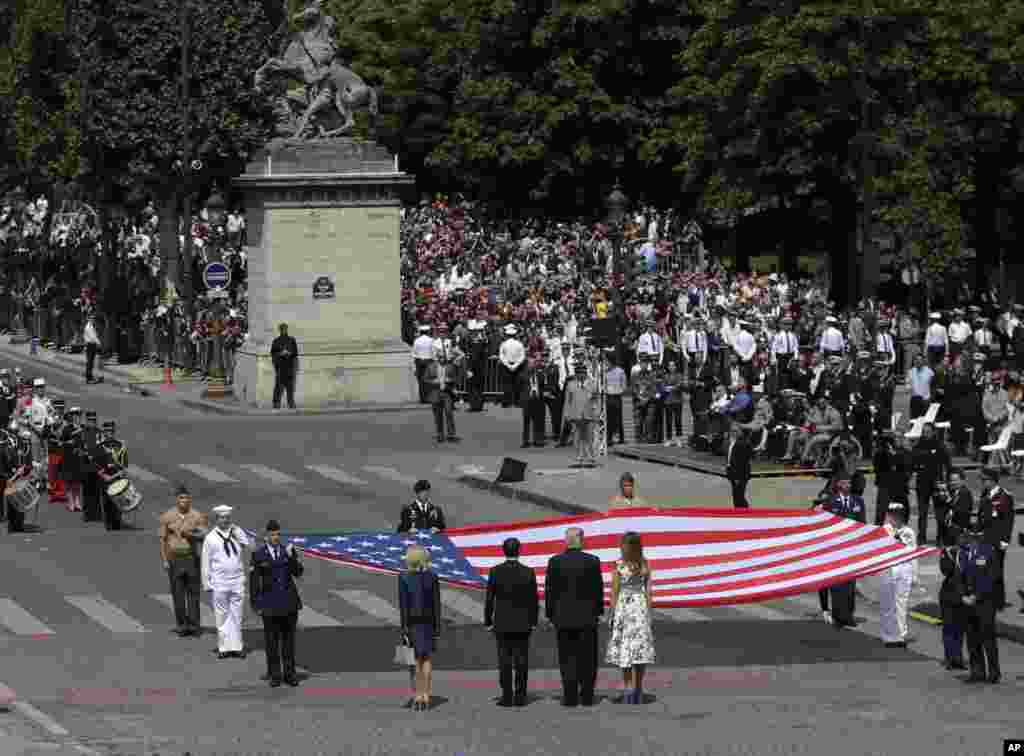 2017年7月14日,美国总统特朗普和夫人,法国总统马克龙和夫人在巴黎国庆游行之后,站在巨大的美国国旗前面