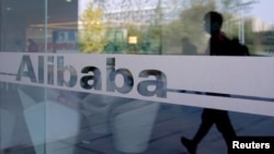 阿里巴巴总部大楼玻璃门上的行走者映像(路透社照片)