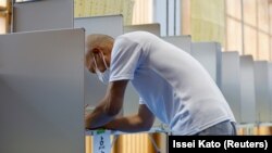 2022年7月10日,在日本东京的一个投票站,一名选民正在准备投票.